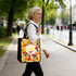 A woman holds a vibrant, multi-coloured tote bag featuring a fruit pattern while walking on a city street.