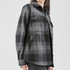 A women's Highland plaid shacket in black and grey, featuring a button-up front and two chest pockets.