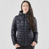 A woman is wearing a navy puffer jacket with a hood, featuring a quilted pattern and a front zipper.