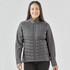 A grey women's softshell jacket with a quilted front and a zip-up design, featuring a logo on the chest.