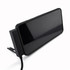 A black charging cable is positioned next to a sleek, black electronic device with a large screen.