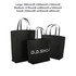 A set of three black boutique paper bags of varying sizes, featuring handles and a logo on the medium bag.