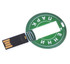 A round, green flash drive with a circular design and a USB connector extending from one side. It features a branding logo.