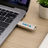 A silver double-end swivel Type C flash drive plugged into a laptop, with a small plant and notebook in the background.