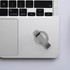A silver Titan Flash Drive placed on a laptop's keyboard, alongside a minimalistic desk setup.