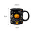 A black ceramic coffee mug featuring Halloween designs, including a pumpkin, bats, and skulls, with a custom spinner toy.
