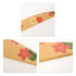 A bamboo nail file in beige with floral patterns in red and yellow. Features a logo on the side.