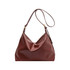 A brown polyurethane tote bag with a slouchy design and a long shoulder strap. It features a small logo.