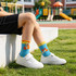 Ear-shaped crew kids' socks feature a vibrant blue design with yellow cuffs and playful animal patterns.