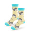 Woven socks featuring a playful design of grey and yellow narwhals on a light yellow background with turquoise accents.