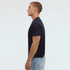 A navy blue Essential/Surf Tee displayed on a model in profile, showcasing its fit and design.