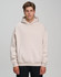 A model wearing a unisex premium fleece oversized hoodie in a light beige colour, featuring a front pocket and a hood.