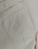 A close-up of a light beige cotton blend long-sleeve shirt, featuring a chest pocket and a button detail.