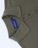 An olive green cotton/poly pique short-sleeve polo shirt with a collar and buttons, featuring a branding label.