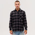A long sleeve flannel shirt featuring a black and grey check pattern, with a pocket and a branded logo.