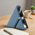 A blue silicone pen holder featuring two triangular compartments, filled with pens, sticky notes, and clips.
