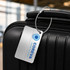 A silver luggage tag with a wire cable, attached to a black suitcase, featuring a logo.