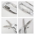 A silver multifunctional carabiner with various tools including a knife and file, featuring a textured grip.