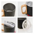 A drink bottle featuring a black stainless steel body, a wooden handle, and a clear lid.