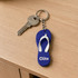 A blue and white thongs-shaped EVA keychain with a metal key attached, featuring a logo.