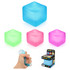 A set of squishy stress relief cubes in blue, green, pink, and purple, alongside a hand squeezing a similar cube.