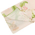 A folded twill weave square scarf in soft hues of pink and green with a floral design, featuring a logo.