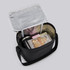 A black cooler bag with a silver interior, containing wrapped gifts and a drink bottle.
