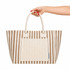 A hand holds a striped brown and cream tote bag featuring a front pocket and dual handles.