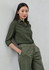 A green long sleeve button-up shirt is worn with matching trousers, displayed against a light background.