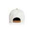 A white two-tone cap featuring a tan strap at the back and a black interior. It includes a logo.