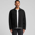 A man wearing a black canvas chore jacket with button closure and multiple pockets. The background is plain grey.