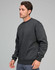 A man wearing a dark grey crew fleece sweatshirt, featuring a relaxed fit and ribbed cuffs.