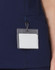 A navy scrub top with a pocket and a badge holder attached.