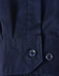 A close-up of a blue long-sleeve shirt featuring segmented tape, with a buttoned cuff detail.