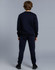 Kid's fleecy trackpants in navy, featuring cuffs, knee padding, and a logo. Worn with a matching navy top.