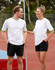 A white unisex short sleeve tee is displayed on a male and female model, set against an outdoor sports background.
