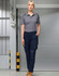 Unisex navy cargo work pants with multiple pockets, worn with a grey polo shirt. Features a logo.