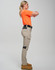 Work pants in beige with black accents, styled on a model wearing an orange top, showcasing a side view.