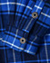 A blue and navy quilted flannel shirt featuring a checked pattern and button details on the cuffs.