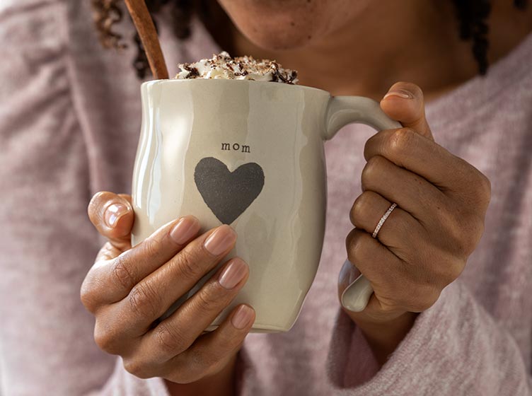 md-mom-mug.jpg mom holding a warm mug with Mom and heart decoration filled with hot chocolate