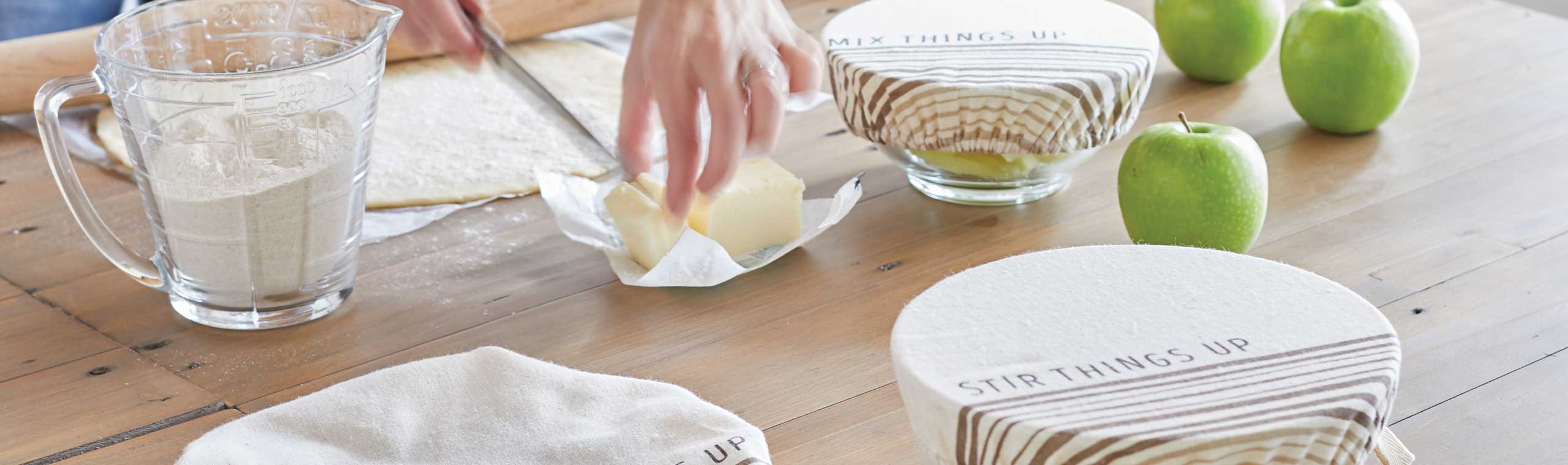 a woman using a knife o cut butter while preparing other foods