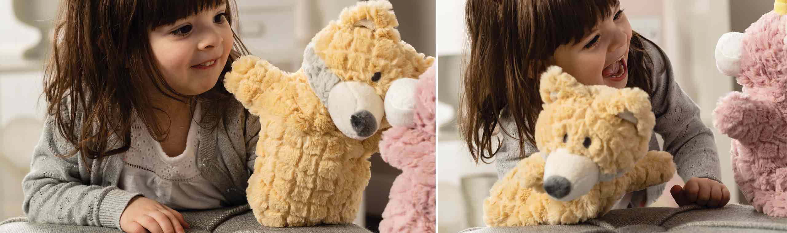 a little girl playing with a yellow and pink stuffed animal