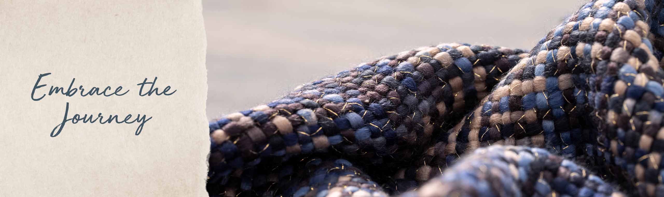 Embrace the journey. close up of the blue texture of a blue woven scarf with gold threads