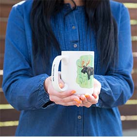 a women wearing a jean jacket holding a mug