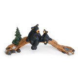 A wood bridge figurine with a large and small black bear sitting together on it.