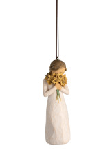 Front view of female figure ornament in cream dress, holding large bouquet of yellow sunflowers up to face