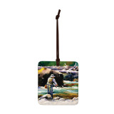 A square hanging ornament with a watercolor image of a man fishing in a river.