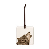 A white square tile hanging ornament with the image of a howling wolf.