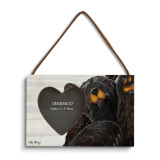 A rectangular wood hanging frame with a 2x2 inch heart shaped photo opening and has a painted image of a waving black bear.