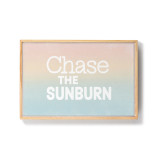 A framed image of sunset colors and the saying "Chase the Sunburn".